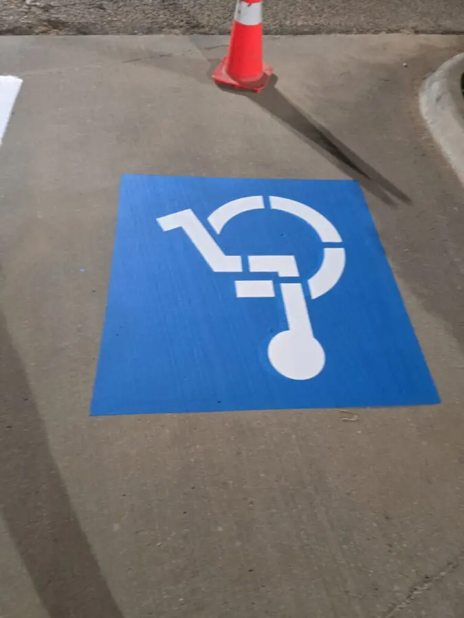 Accessible parking symbol painted on asphalt