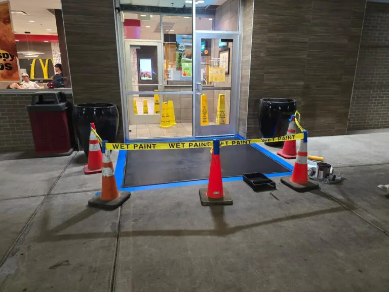 Wet paint tape around a drive-thru window curb