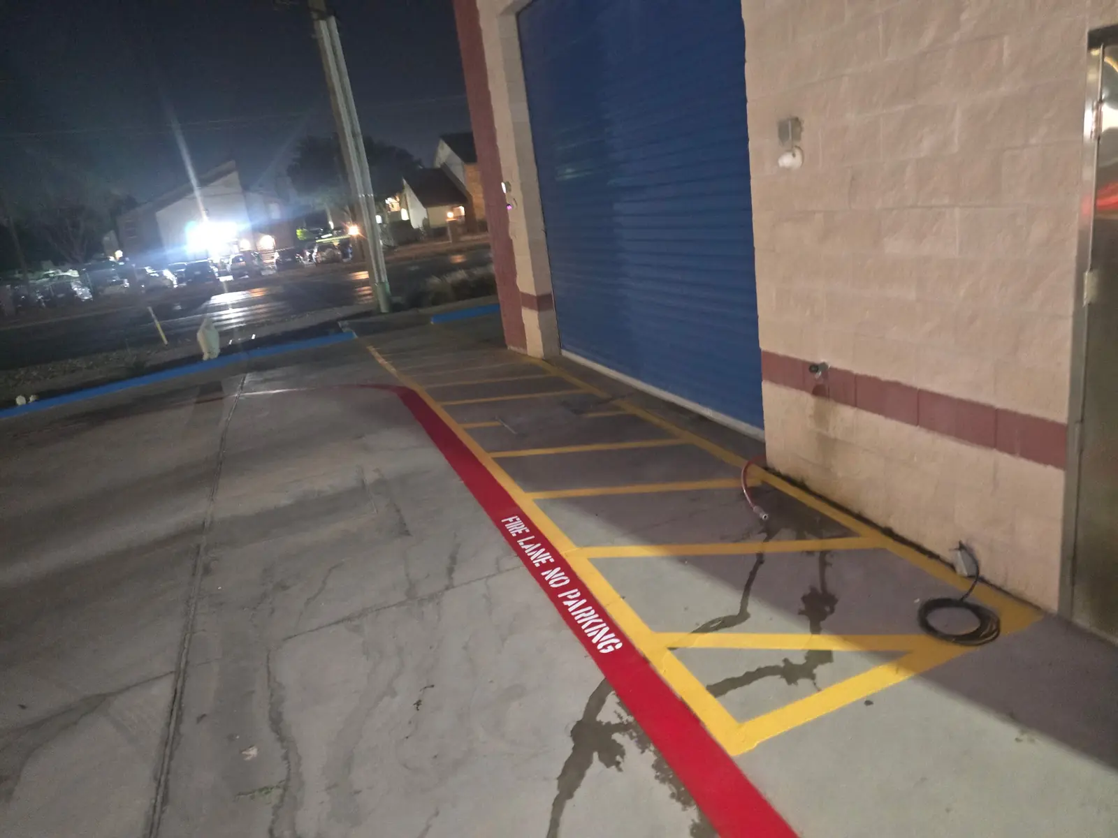 Crosshatch and a red fire lane beside a building entrance
