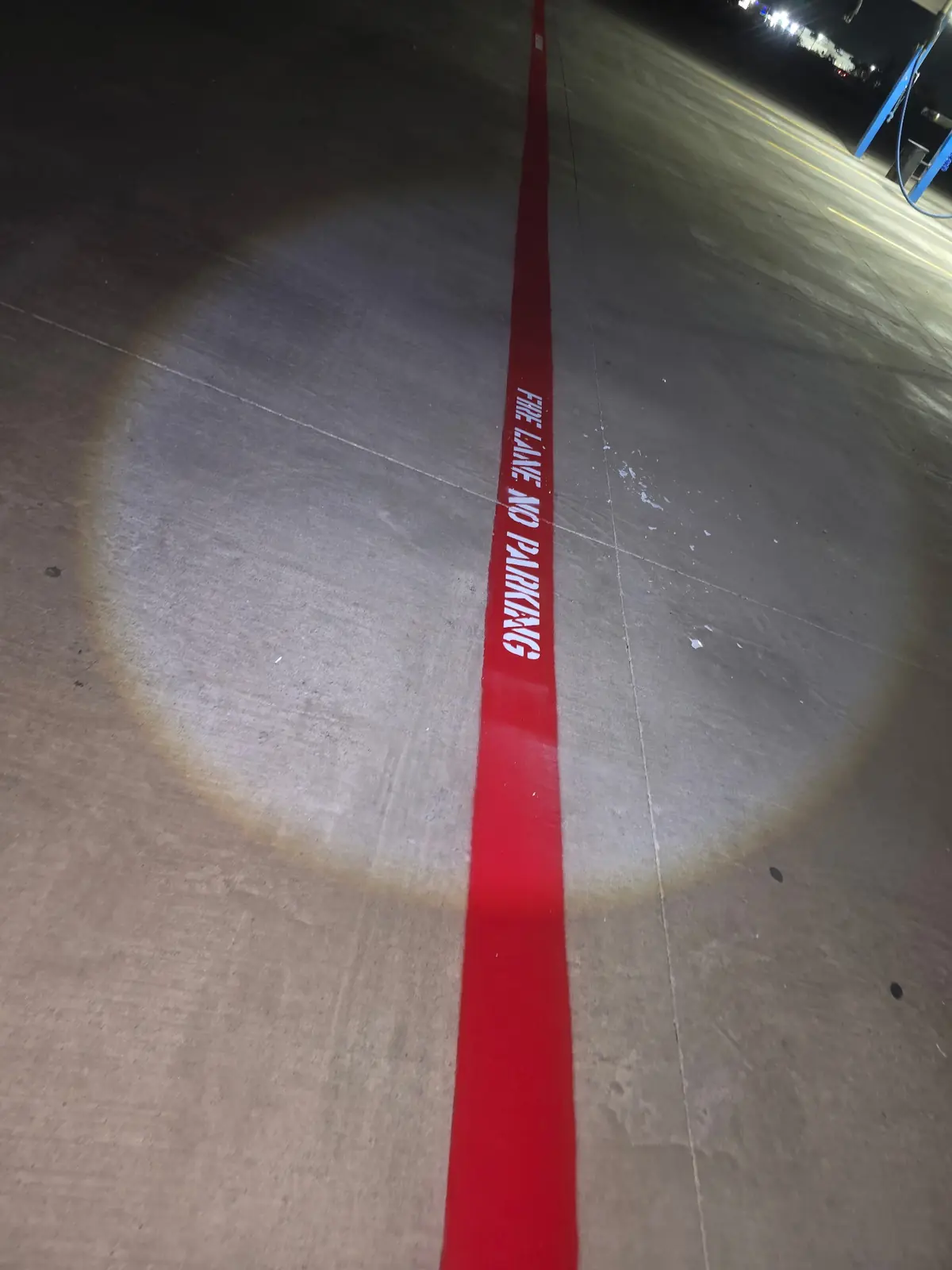 FIRE LANE NO PARKING stenciled on a red lane