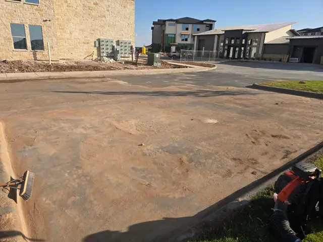Dust and dirt across a pad beside the building