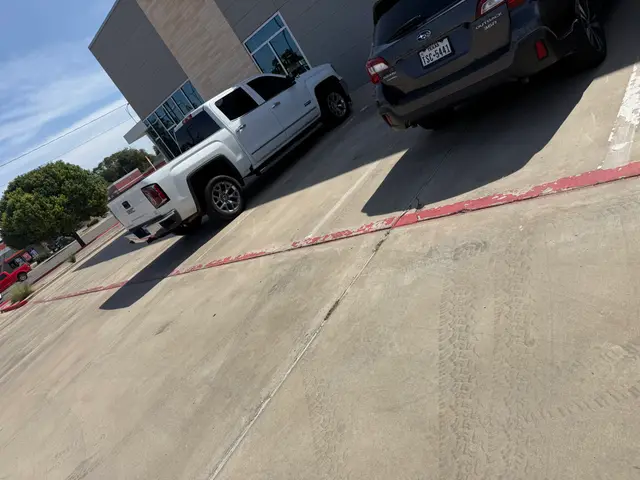 Faded red curb with parked cars